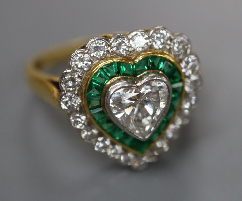 A modern 18ct gold, heart shaped diamond and emerald cluster set heart shaped dress ring, size N, gross 4.7 grams.